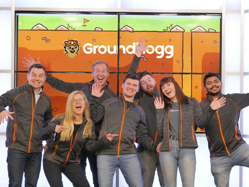 the Groundhoggio team posing in front of the logo