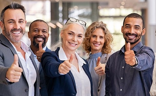 Stock photo of a team giving a thumbs up.