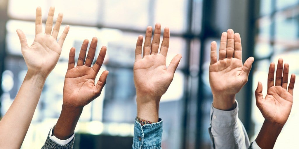 pessoas levantando a mão para se voluntariar