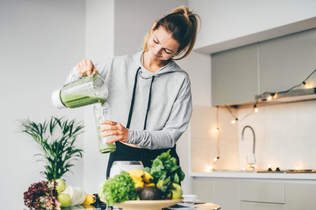 Young Woman Making A Smoothie At Home 