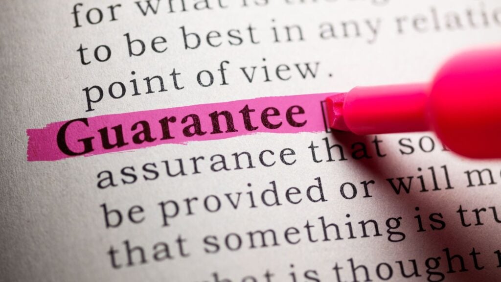 Um close-up da palavra "Garantia" destacada com caneta rosa.