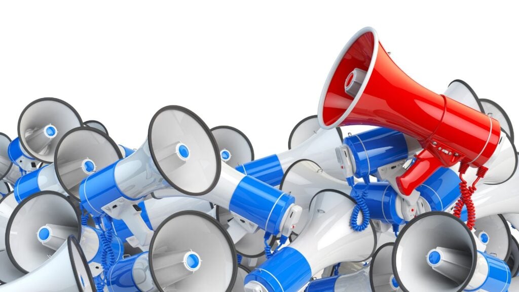 a red megaphone amidst a pile of white and blue megaphones