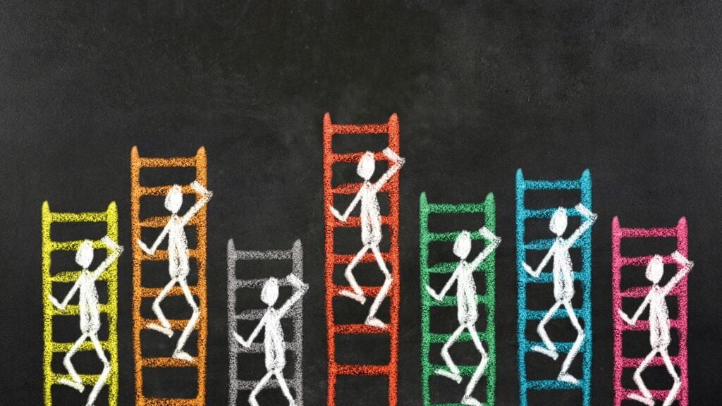 Chalk drawings of stick people trying to climb up ladders.