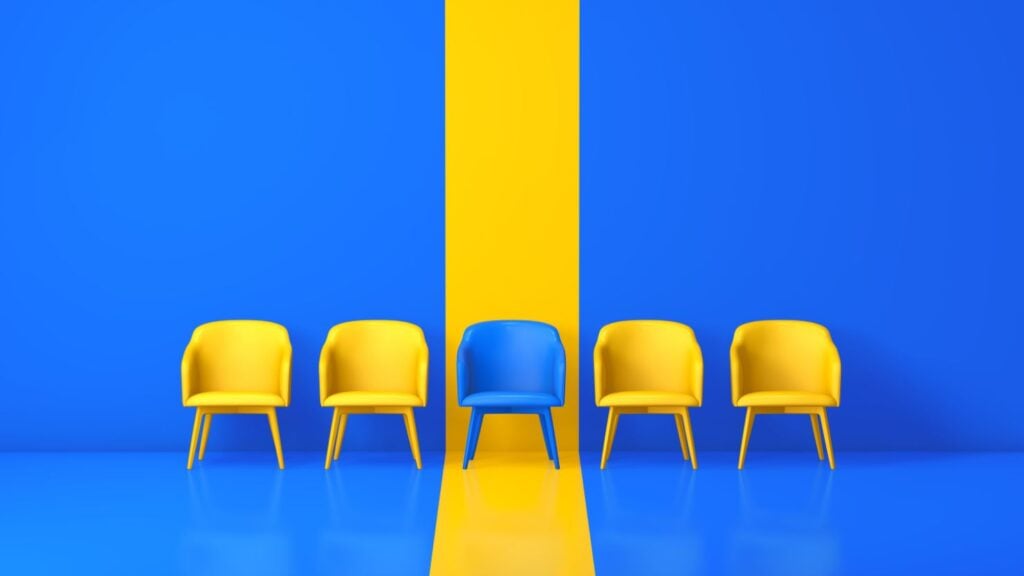 a blue chair that stands out from all the yellow chairs