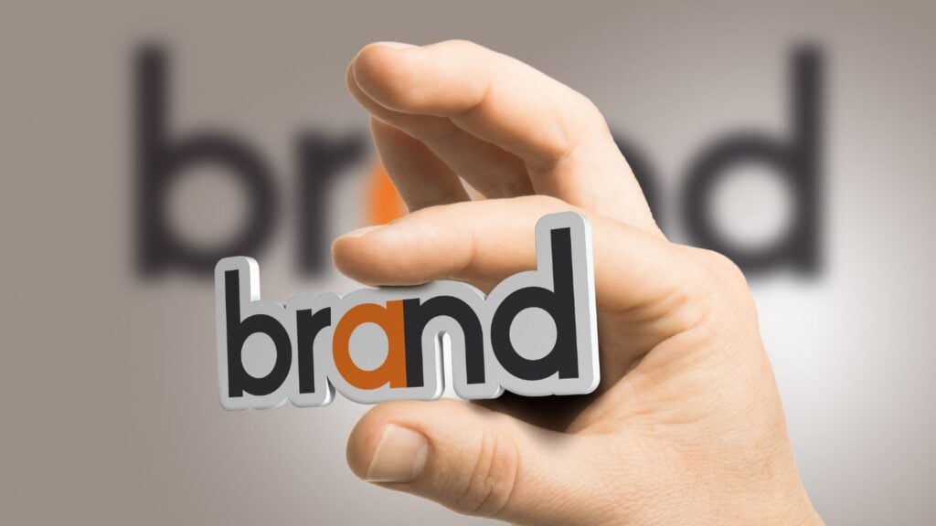 a hand holding the word "brand"
