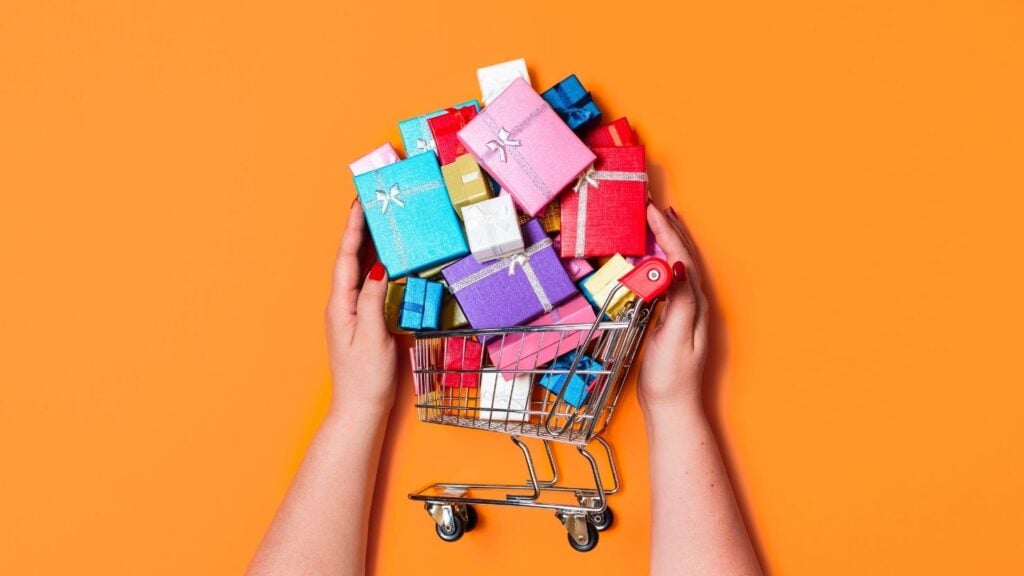 Person mit einem Einkaufswagen voller Geschenke, um das Konzept des Upsellings oder des Hinzufügens von mehr Waren zum Warenkorb zu verdeutlichen