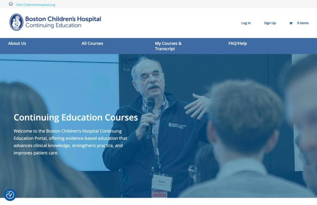 Boston-Childrens-Hospital | MemberPress Speaker presenting with a microphone at a Boston Children's Hospital Continuing Education event, foreground audience blurred in the image.
