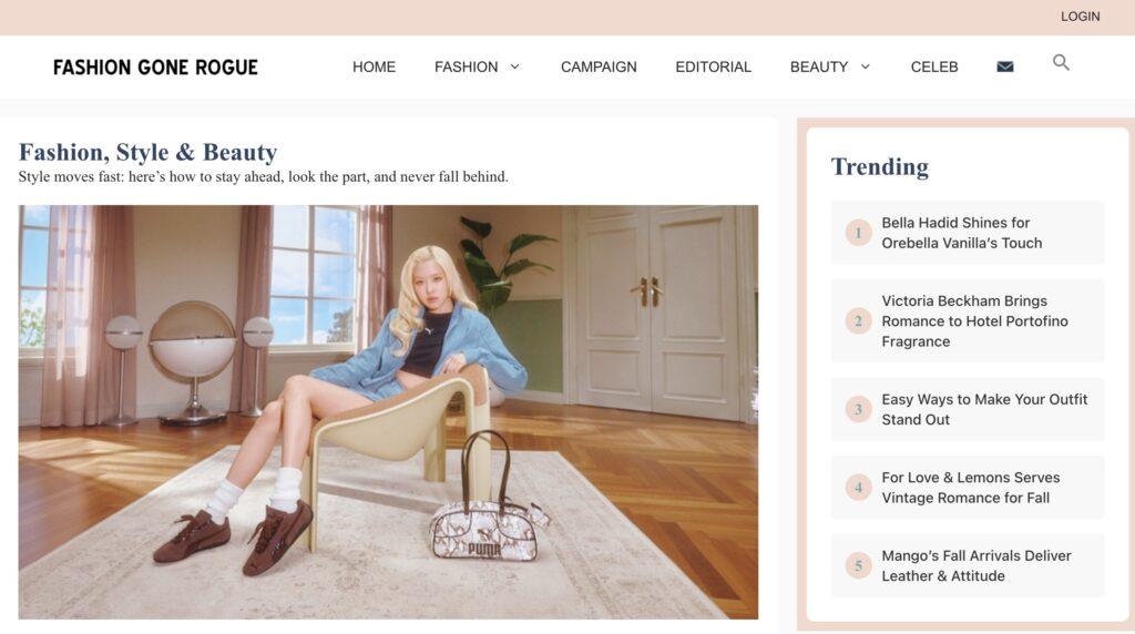 Fashion Gone Rogue Homepage Screenshot | MemberPress Blonde model in a blue jacket sitting in a chair in a bright living room with wooden floors and fashion bags nearby.