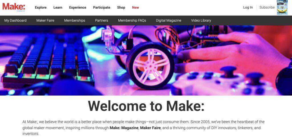 Make Homepage Screenshot | MemberPress Person's hand adjusts a small wheeled robot on a desk with a backlit keyboard and game controller nearby