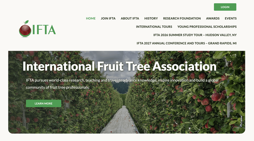 Hero banner showing an apple orchard path with trees full of apples, overlaid by the text'International Fruit Tree Association' and a subtitle about research and knowledge.